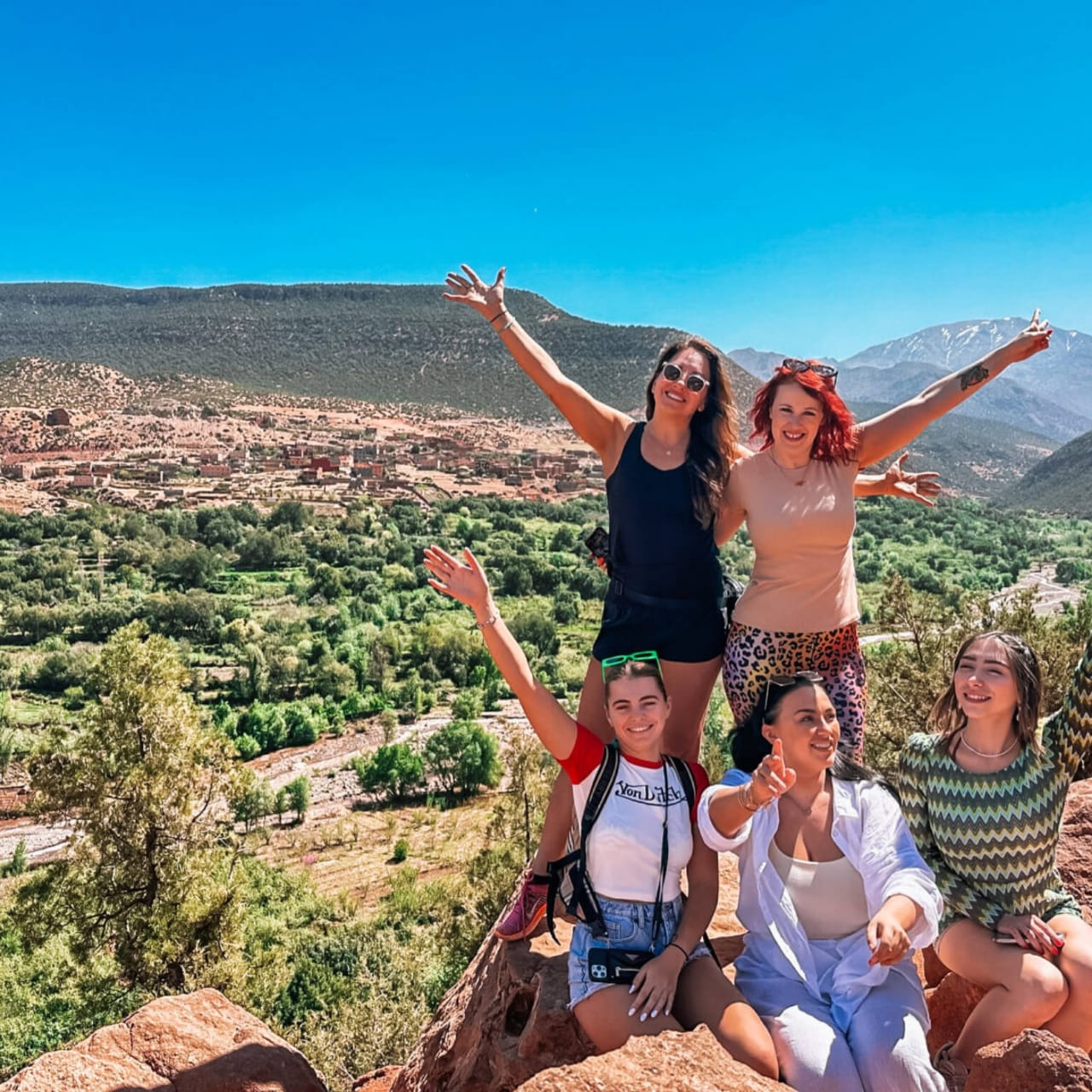 A trekking group at a High Atlas valley viewpoint with layered ridges behind