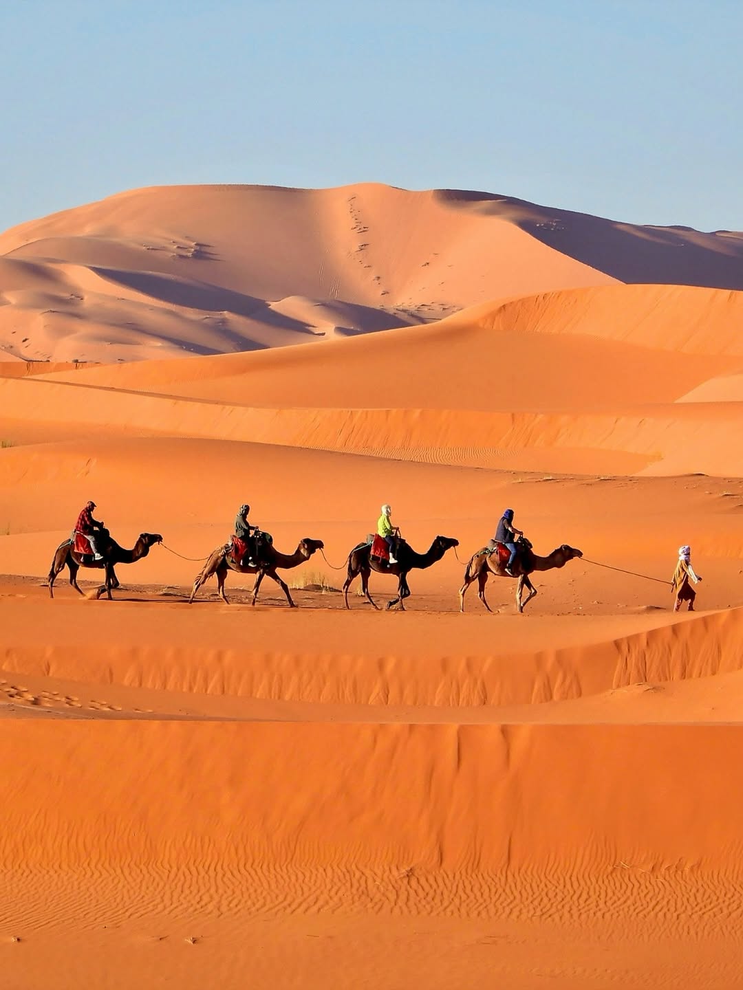 Nascimento do sol sobre as dunas onduladas de Erg Chebbi em Merzouga no deserto do Saara em Marrocos
