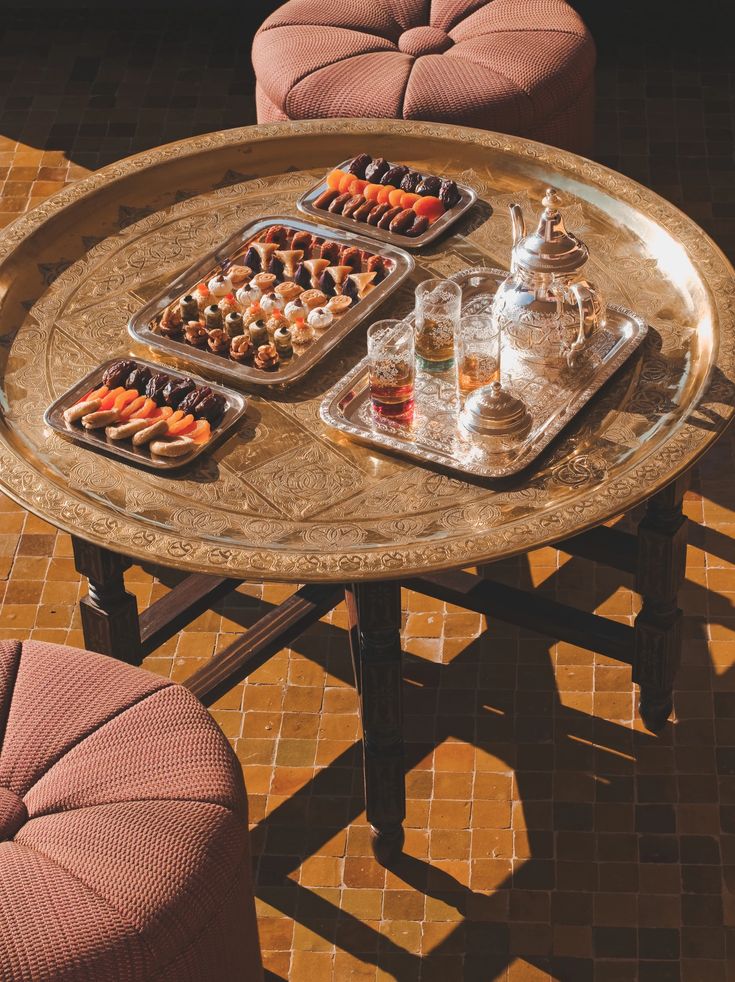 A brass tray set with Moroccan pastries, dried fruit, tea glasses and a silver teapot