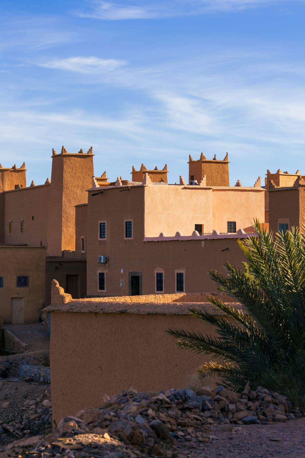 Murallas almenadas de kasbah ocre y palmeras en Ouarzazate, puerta de entrada al Sáhara marroquí