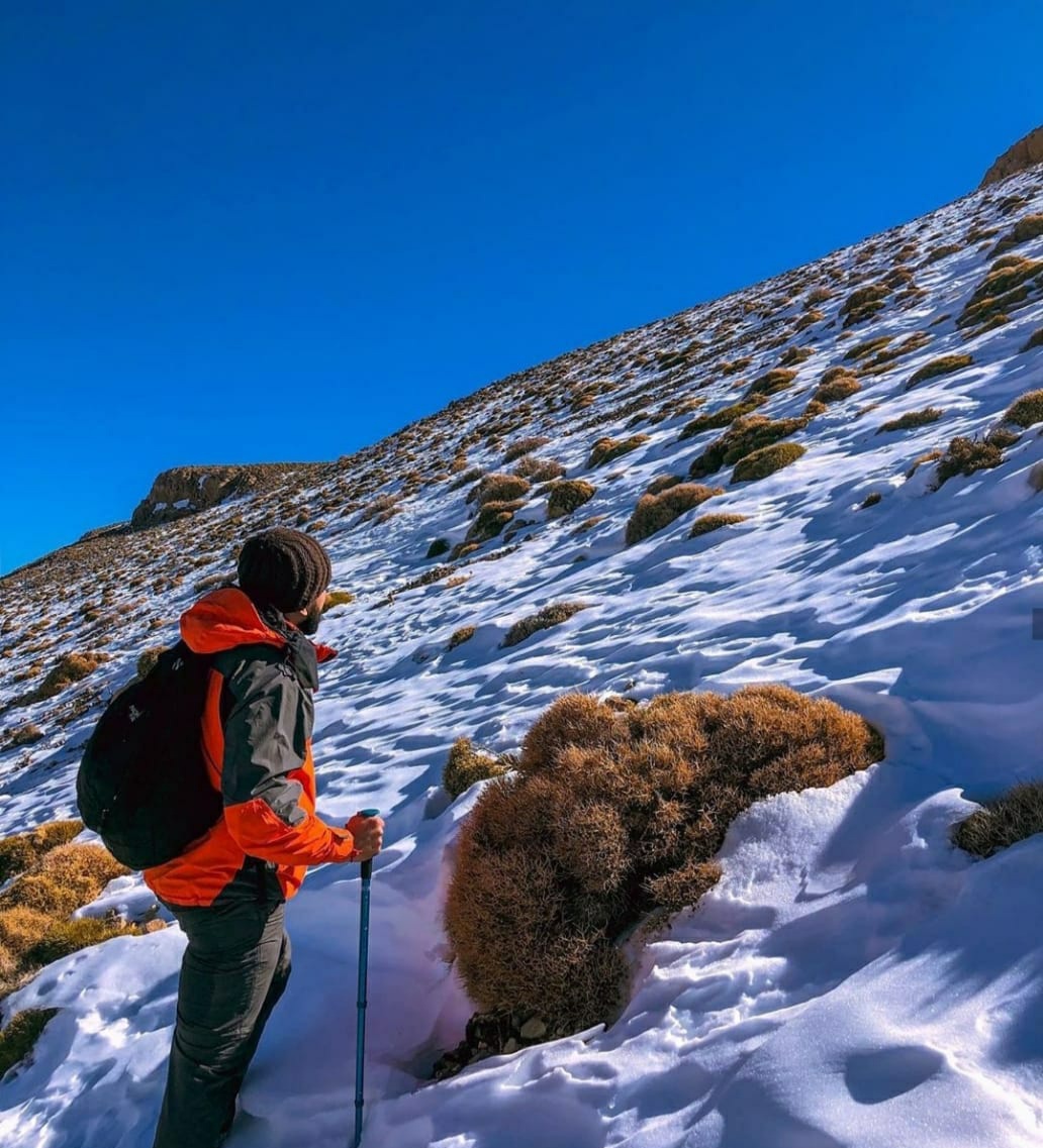 Montañeros cruzando una ladera nevada en el Alto Atlas marroquí