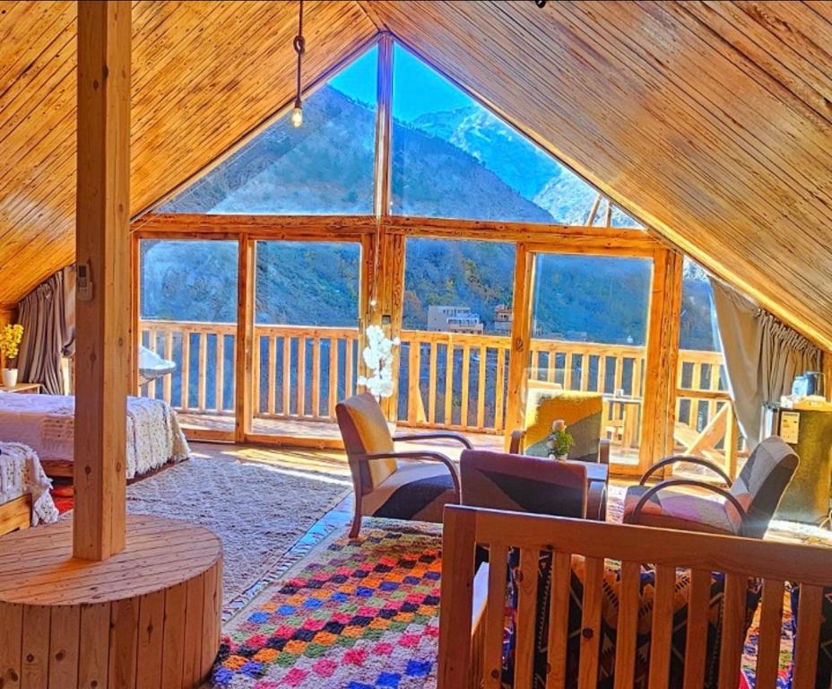 Timber-lined upper room at Afla Sky Views with a large gable window opening onto the mountainside