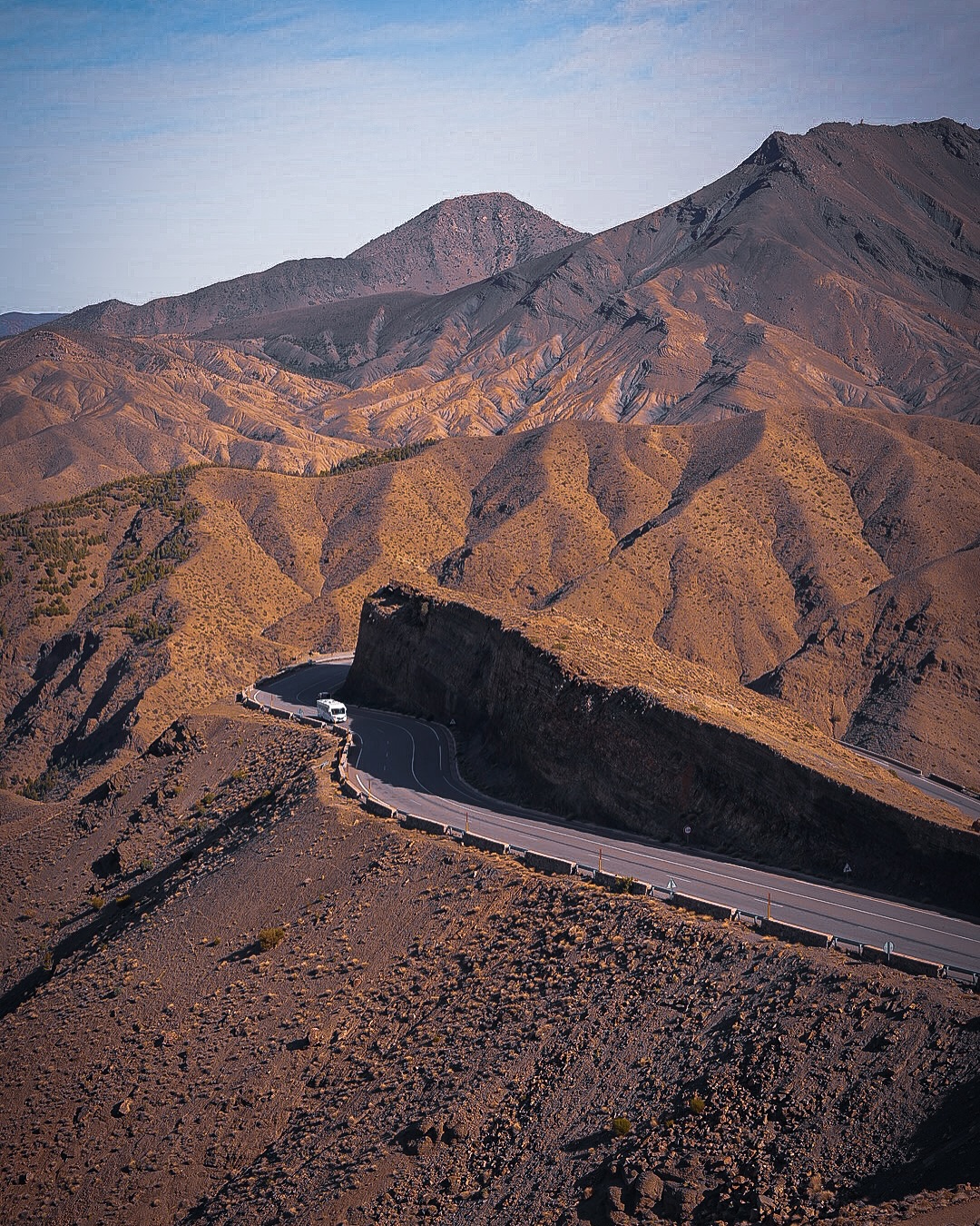 A minibus rounding a hairpin bend on the winding Tizi n'Tichka mountain road