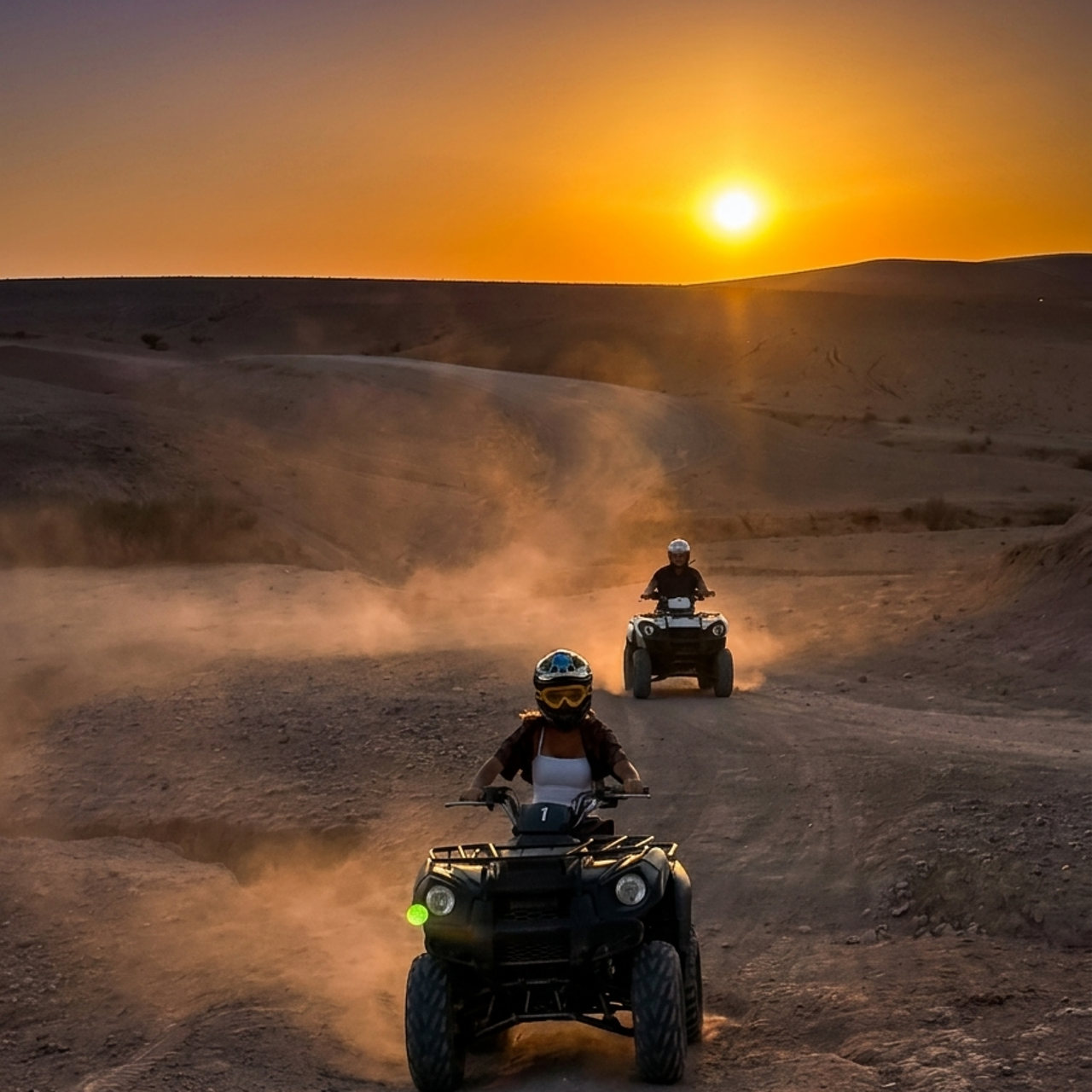 Agafay quad bike ride following a dusty desert trail towards the setting sun