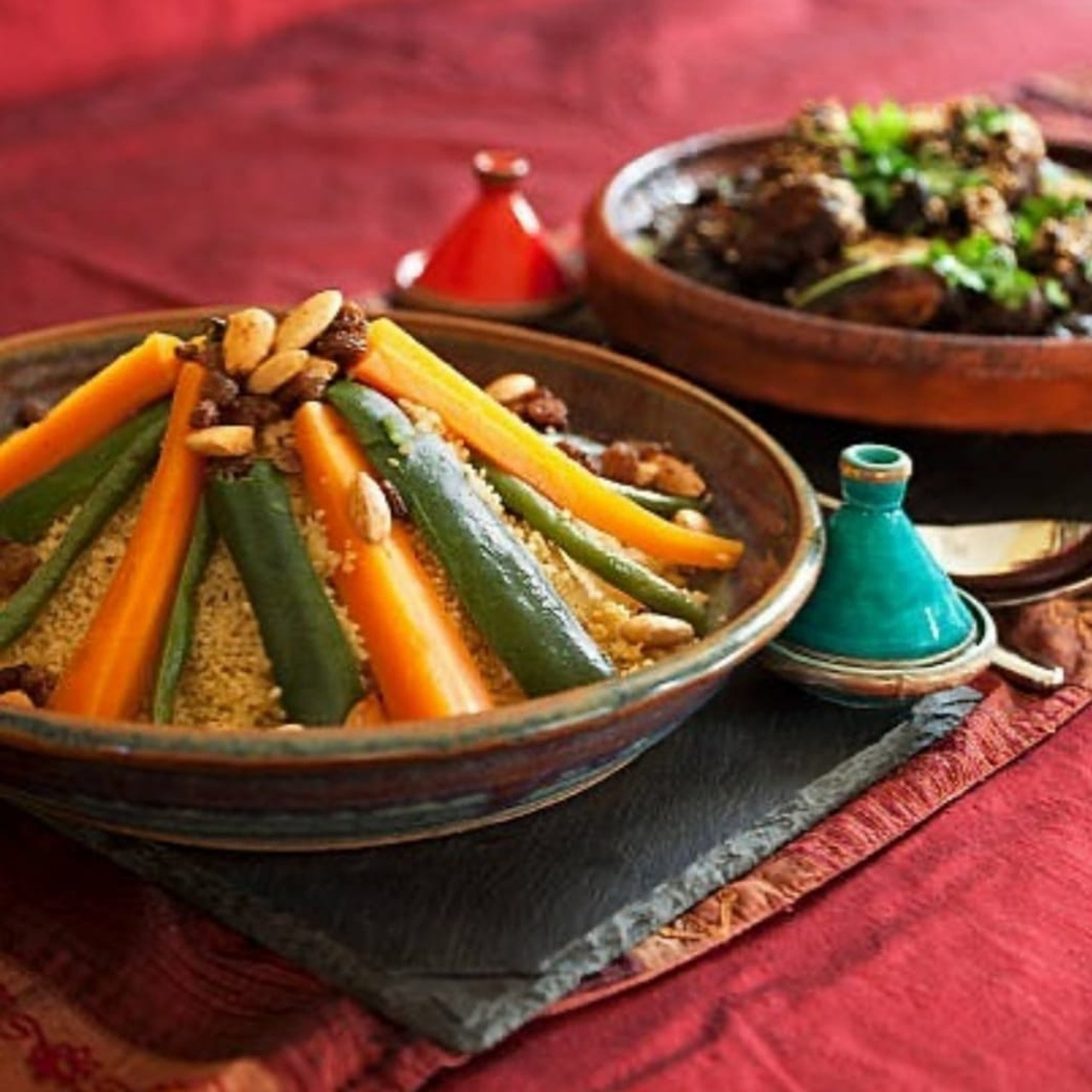 Cuscús marroquí con zanahorias, calabacín y almendras servido junto a un tagine de carne