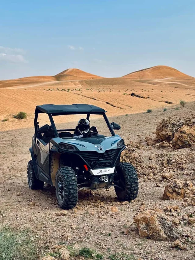 Un buggy su una pista sassosa nel deserto di Agafay con le colline aride del deserto di pietra sullo sfondo