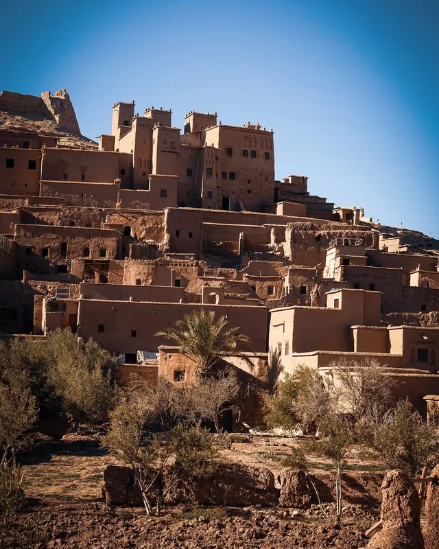 The earthen kasbah village of Aït Ben Haddou rising above olive trees and gardens