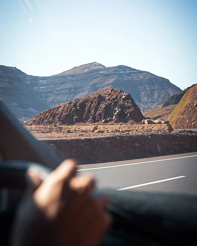 Bare Atlas ridges and a mountain pass seen from the window of a moving vehicle