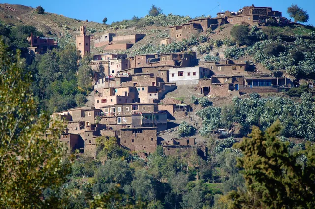 A Berber village of earth-built houses stacked up a green Atlas hillside