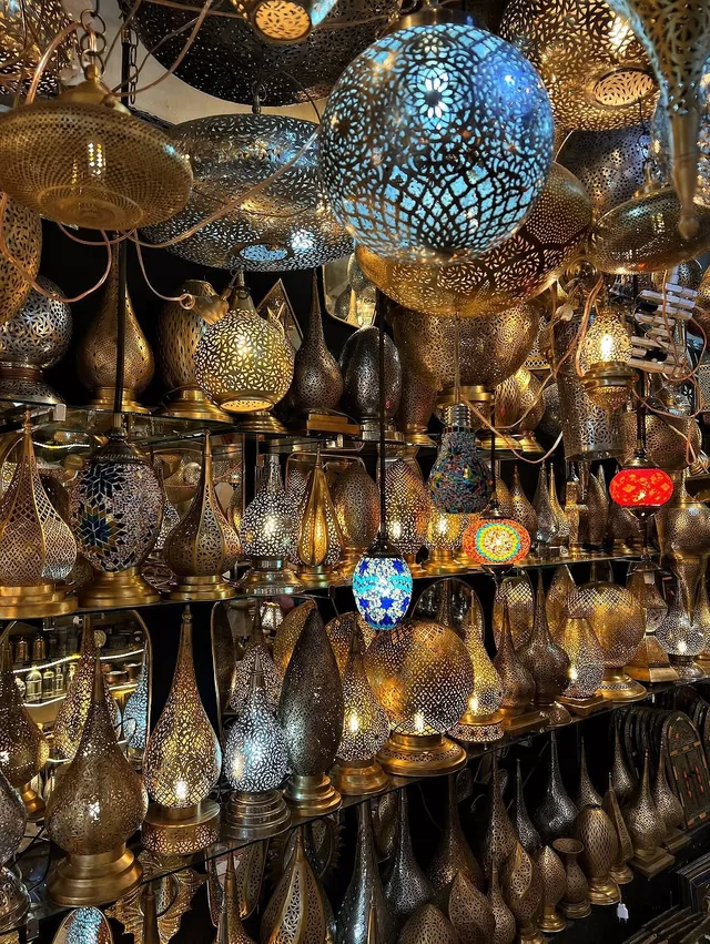 A souk shop lit by rows of pierced brass and mosaic lanterns
