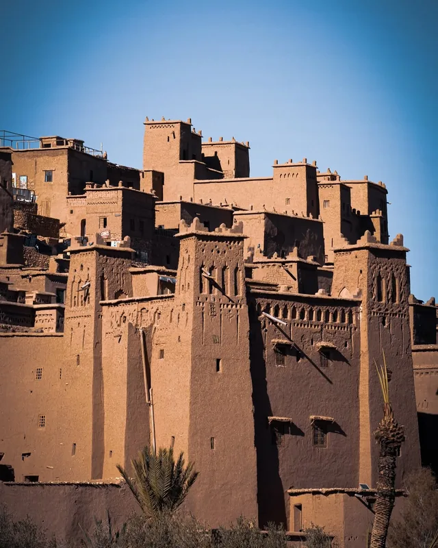 Carved earthen towers of the Aït Ben Haddou ksar rising against a deep blue sky