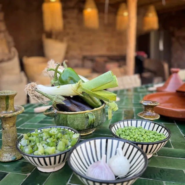 Fresh peppers, leeks, aubergine, peas and garlic in ceramic bowls on a green tiled cooking table
