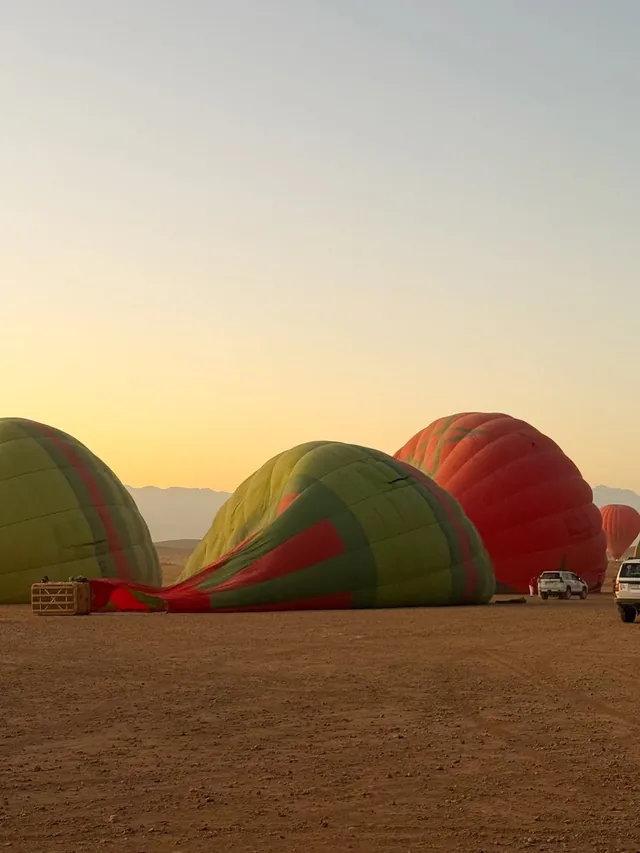 Hot-air balloons being inflated on the desert floor at first light near Marrakech