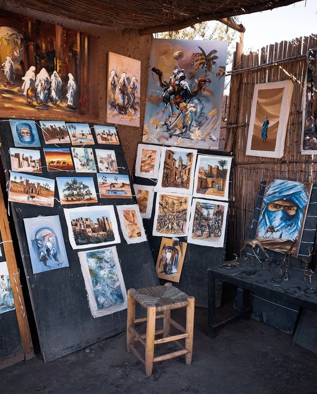 A local painter's roadside stall hung with desert and kasbah canvases in southern Morocco