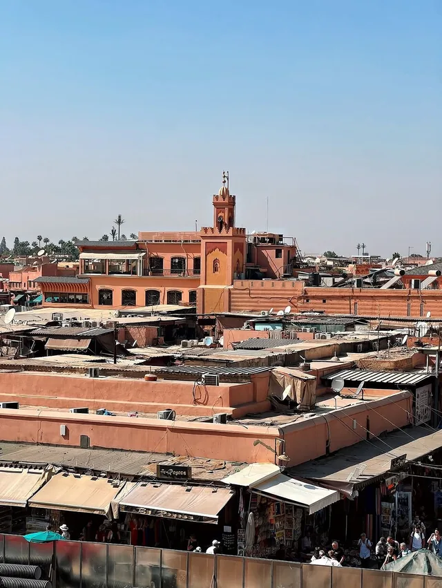 Pink Marrakech rooftops, a minaret and terrace cafes seen above the Jemaa el-Fnaa area