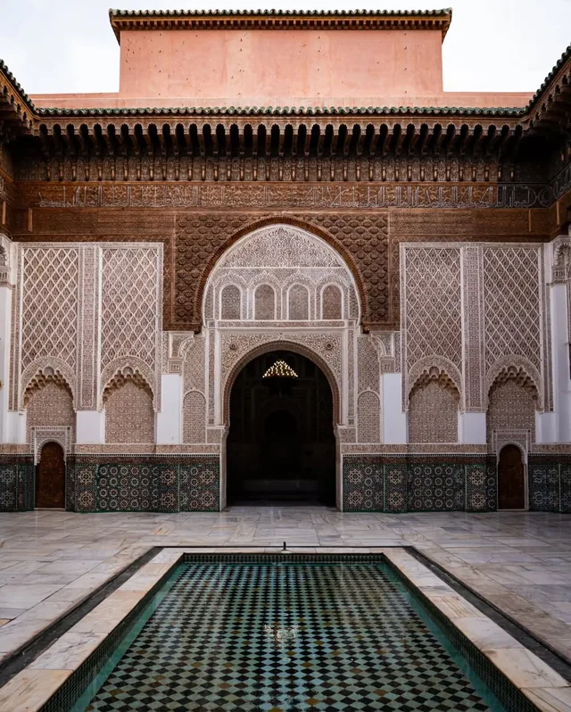 The reflecting pool and carved cedar and stucco facade of the Medersa Ben Youssef courtyard