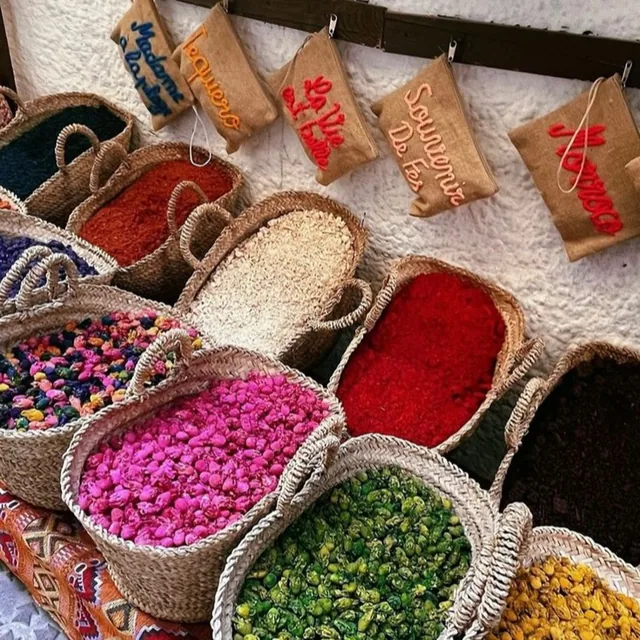 Woven baskets filled with dried rosebuds, spices and coloured flowers at a medina shop