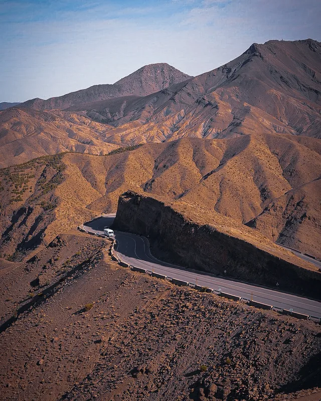 A minibus rounding a hairpin bend on the winding Tizi n'Tichka mountain road