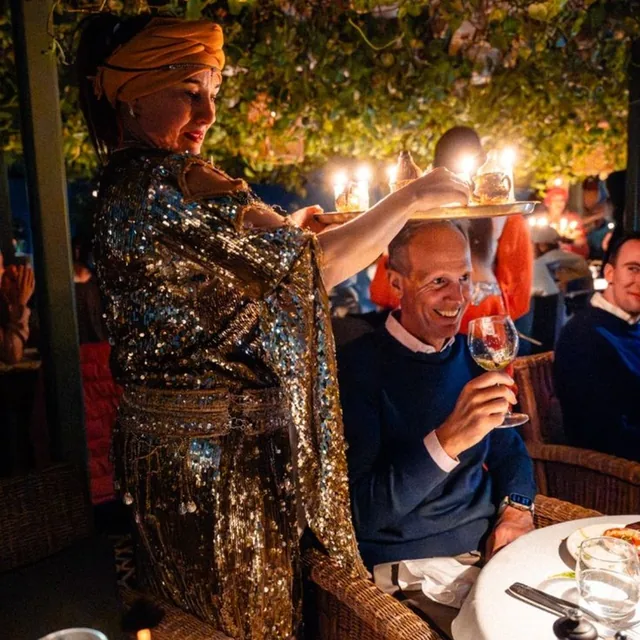 Moroccan mint tea poured for guests during a desert dinner and show