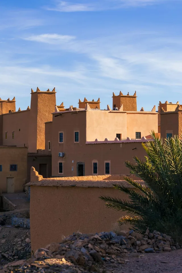 Crenellated kasbah towers and date palms glowing in golden-hour light near Ouarzazate