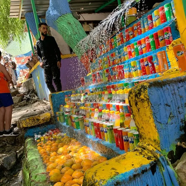 Cold drinks and oranges chilled in running water at a brightly painted riverside stall in the Ourika valley