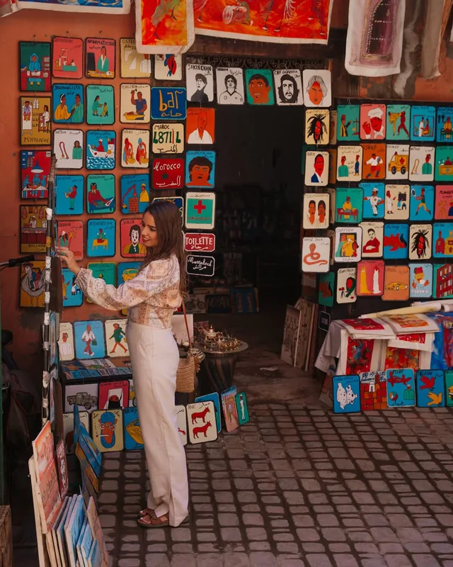 A medina shop hung with hand-painted Moroccan folk art panels and signs