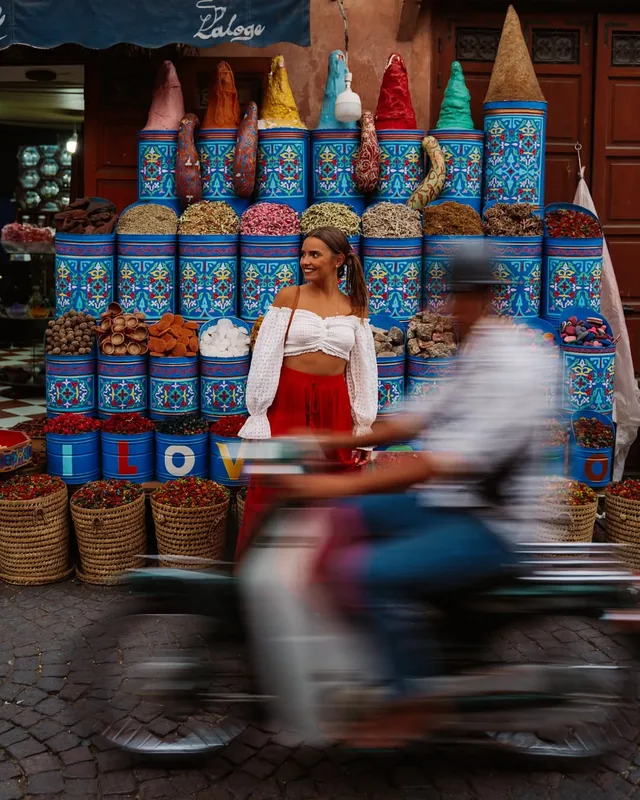 Brightly painted spice drums filled with rose petals and dried herbs on a medina street