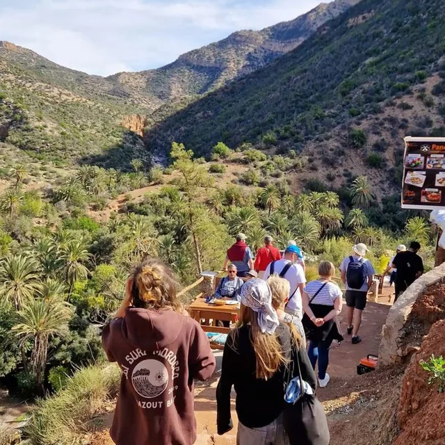 A guided group walking down a palm-filled gorge path in Paradise Valley near Agadir