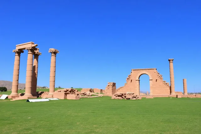 Standing Roman columns and an arch among ancient ruins on a green plain in northern Morocco