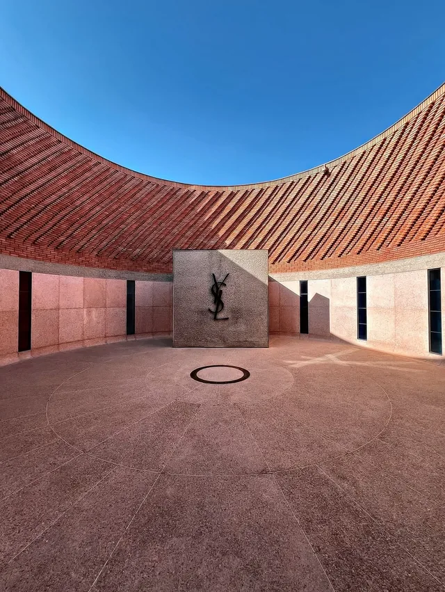 Curved terracotta brickwork and pink stone courtyard of a contemporary Marrakech museum